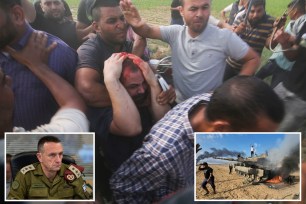 Palestinian militants celebrating near an Israeli tank at the border fence of the Gaza Strip after an unprecedented attack on Israel