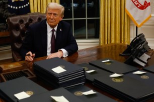 President Donald Trump signing executive orders at his desk in the Oval Office on his second term inauguration day, January 20, 2025.