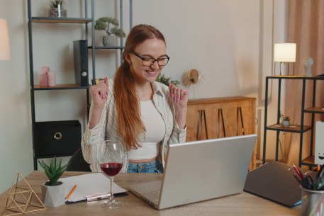 A young woman celebrates her student loan refinance.