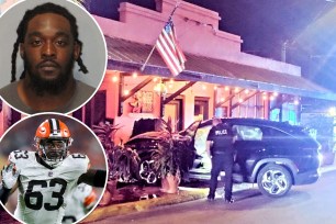 Former Cleveland Browns defensive lineman Lonnie Phelps standing in front of a car after allegedly crashing it into a restaurant