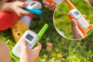 A close up of a hand holding a walkie talkie